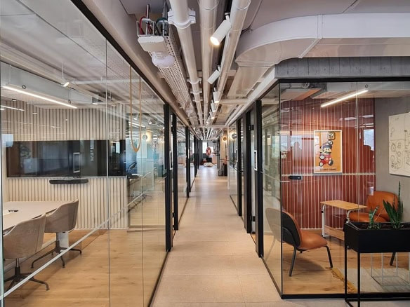 מסדרון משרדים מודרני בצומת אסטרטגית, עם חדרי ישיבות בעלי קירות זכוכית משני הצדדים, תקרות חשופות, כיסאות משרדיים, שולחנות ועציצים. שטח ההשכרה הכולל הוא 600 מ"ר.