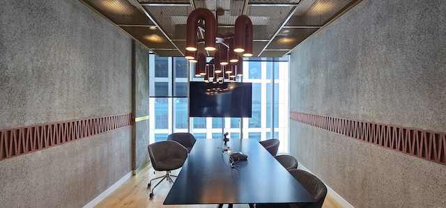 חדר ישיבות מודרני להשכרה במגדל סקיי ת"א, הכולל שולחן שחור ארוך, כיסאות מסוגננים, טלוויזיה המותקנת על הקיר, תאורה תקרתית וחלונות גדולים — מושלם כמשרד מרוהט המוכן לצרכי העסק שלכם.