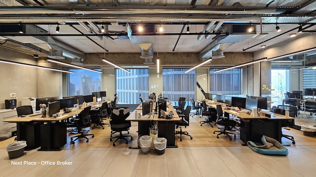 משרד מודרני בעל חלל פתוח עם מספר שולחנות, מחשבים וכסאות; חלונות גדולים ברקע חושפים נוף עירוני — מושלם להשכרה במגדל אקרו, המציע חלל עבודה מובחר עם נוף מרהיב. אין אנשים במקום.