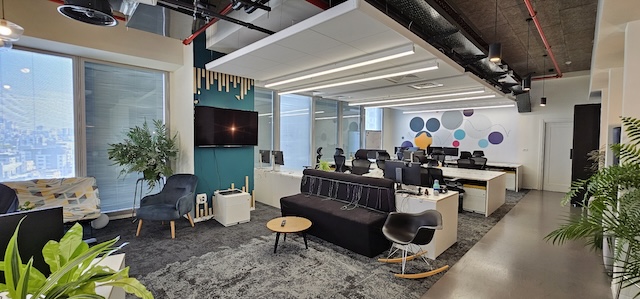 משרד להשכרה במגדל אטריום, 600 מ"ר עם מספר עמדות עבודה, כיסאות ארגונומיים, אזור לאונג', צמחייה טבעית וחלונות גדולים המלאים באור טבעי.